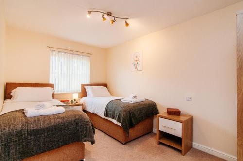 a bedroom with two beds and a window at Harris House in Doncaster