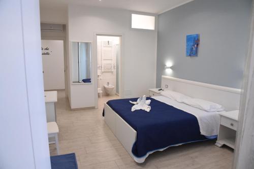 1 dormitorio con 1 cama grande con manta azul en B&b VICTORIA, en Porto Cesareo