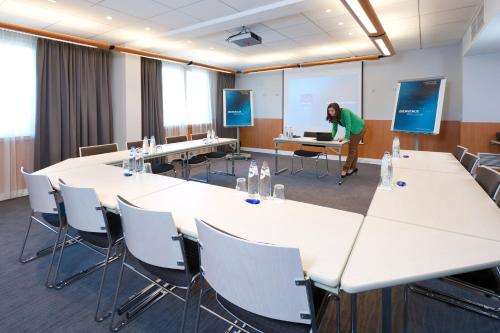 a person standing in a room with a conference room at Novotel Leuven Centrum in Leuven