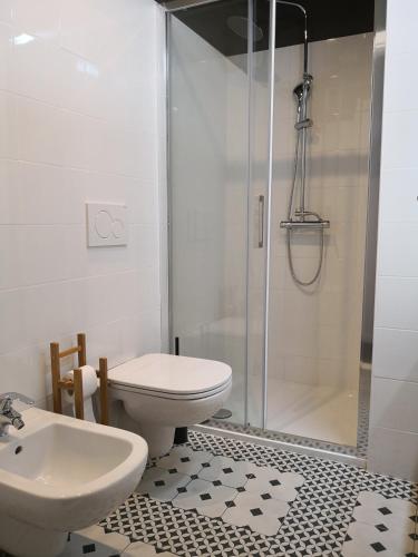a bathroom with a shower and a toilet and a sink at Hotel Villa Rina in Riva del Garda