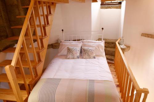 a bedroom with a bed with a wooden staircase at Olá Belém! Cozy Windmill, Stunning views to Lisboa in Caparica