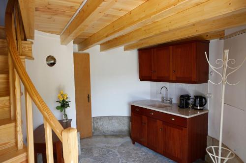 a kitchen with wooden cabinets and a counter top at Olá Belém! Cozy Windmill, Stunning views to Lisboa in Caparica