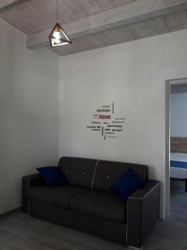 a living room with a black couch against a wall at Casammare in Marina di Modica