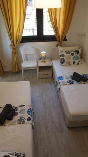 a room with two beds and a table and a chair at Villa Burkopolis in Sozopol