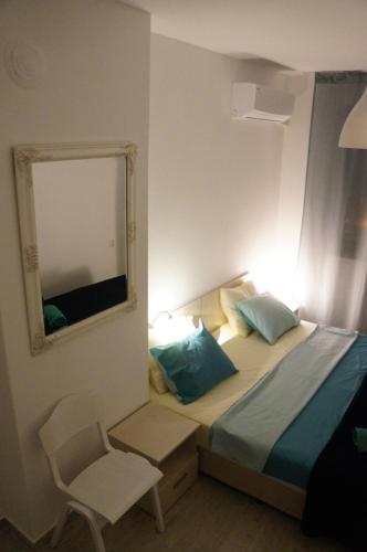 a bedroom with a bed with a mirror and a chair at Villa Burkopolis in Sozopol