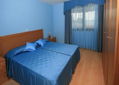 a blue bedroom with a bed with blue sheets and a window at Villa Egida Capris in Lovrečica
