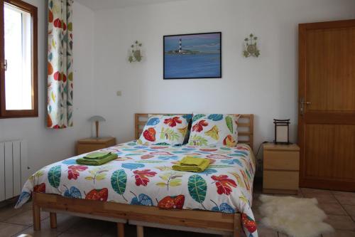um quarto com uma cama com um edredão colorido em Mas dou l'Estele chambre d'hôtes em Arles