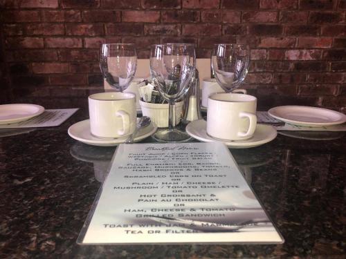 a table with wine glasses and a menu on it at Eastbourne Riviera Hotel in Eastbourne