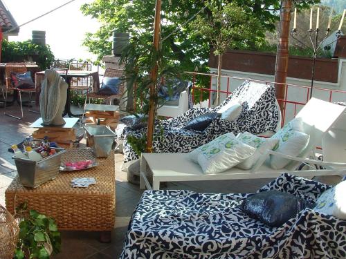 a patio with couches and chairs and a table at Hotel Mignon in Trieste