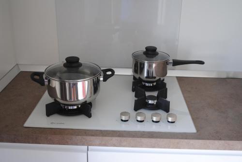 two pots sitting on top of a stove at Agriturismo Il Giardino Degli Ulivi in Lazise
