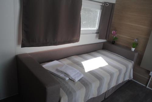 a small bed in a room with a window at Agriturismo Il Giardino Degli Ulivi in Lazise