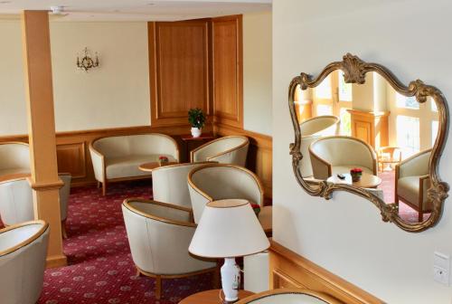 a waiting room with a mirror and chairs at Hôtel Sainte Marie in Lourdes