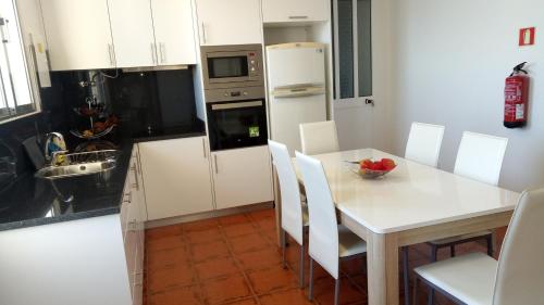 uma cozinha com uma mesa branca e um frigorífico branco em Vivenda Cabral no Funchal