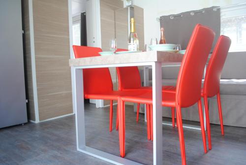 a dining room with red chairs and a table at Agriturismo Il Giardino Degli Ulivi in Lazise