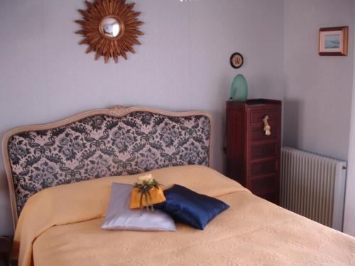een slaapkamer met een bed met 2 kussens en een spiegel bij Patio in Colmar