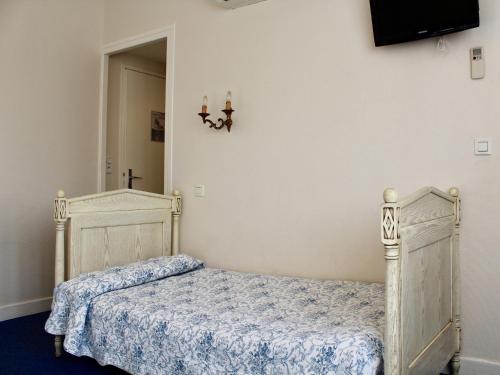 a bedroom with a bed and a tv on the wall at Hôtel Sainte Marie in Lourdes