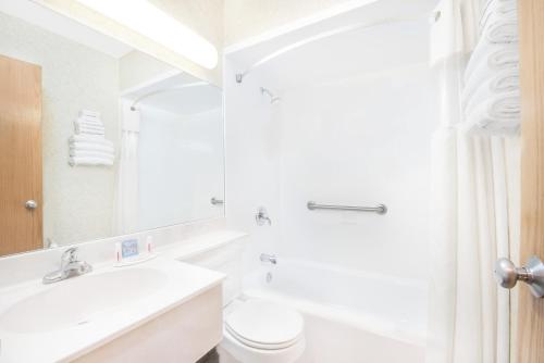 a white bathroom with a toilet and a sink at Days Inn by Wyndham West Rapid City in Rapid City