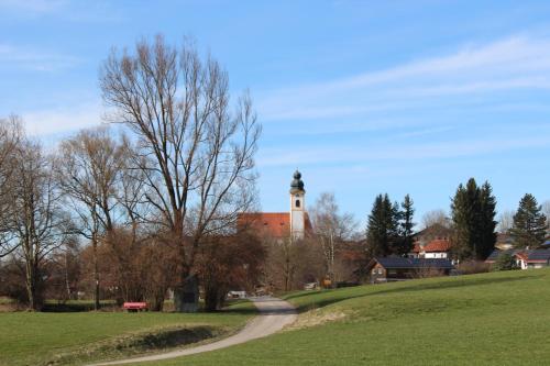 un edificio con una torre de reloj en lo alto de un campo en Ferienwohnung Am Anger, en Amerang