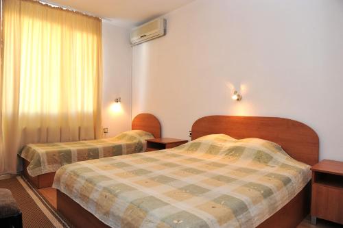 a hotel room with two beds and a window at Family Hotel Blazhi in Sandanski