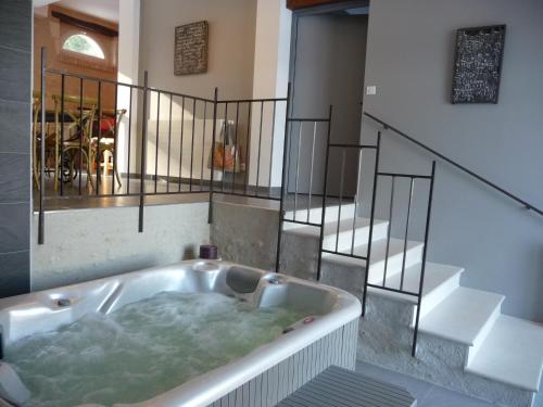 a bath tub in the middle of a room with stairs at Gite du Domaine de la Maison Neuve in Saint-Jean-Saint-Germain