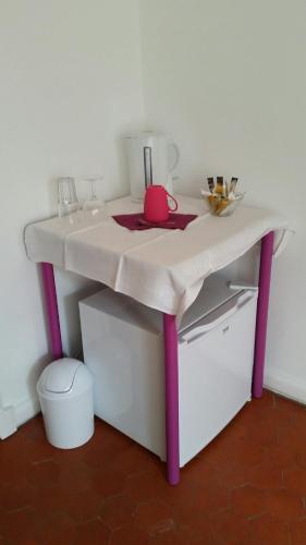 une table blanche avec des jambes violettes et un évier dans l'établissement Villa Belle Rive, à Cannes