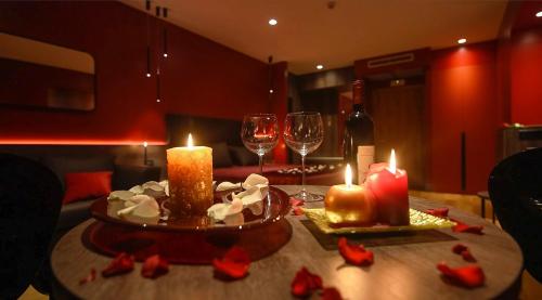 a table with candles and wine glasses and flowers on it at Anusca Palace Hotel in Castel San Pietro Terme