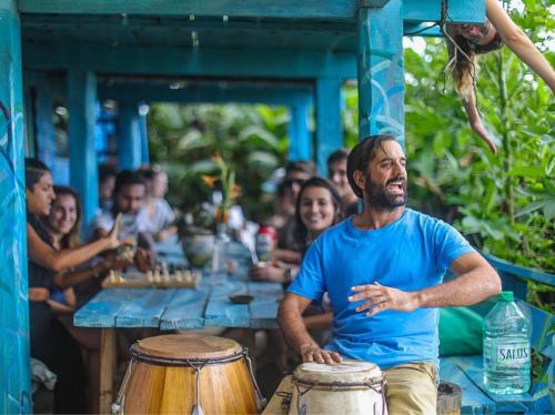 a group of people sitting around a table with drums at Lobo Hostel Bar in Cabo Polonio