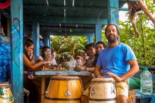 a group of people sitting around a table with drums at Lobo Hostel Bar in Cabo Polonio
