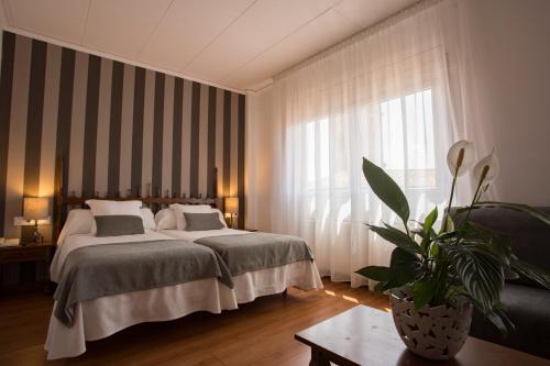 a bedroom with a bed and a large window at Hotel Segle XX in Tremp