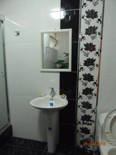 a bathroom with a sink and a mirror and a toilet at B&B Cusing Wasi in Lima