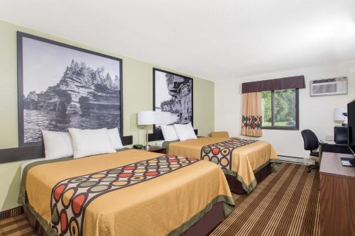 a hotel room with two beds and a desk at Super 8 by Wyndham Eau Claire I-94 in Eau Claire