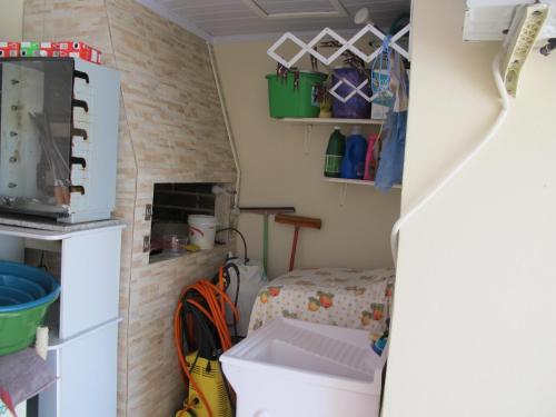 a small room with a bed and a refrigerator at Edícula aconchegante 100m do Mar in Sombrio