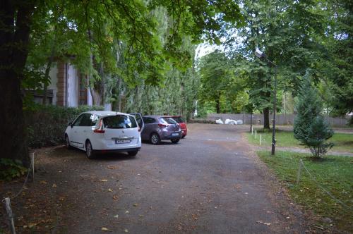 "ハルカーニャ"にあるHarkányi Ragyogó Apartmanの木立駐車場に二台駐車