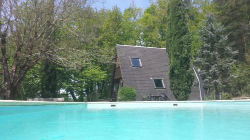 une maison derrière une piscine avec une maison dans l'établissement La Truffière, à Sagelat