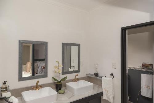 two sinks in a bathroom with two mirrors at Bri-Shel Manor B&B in Heidelberg