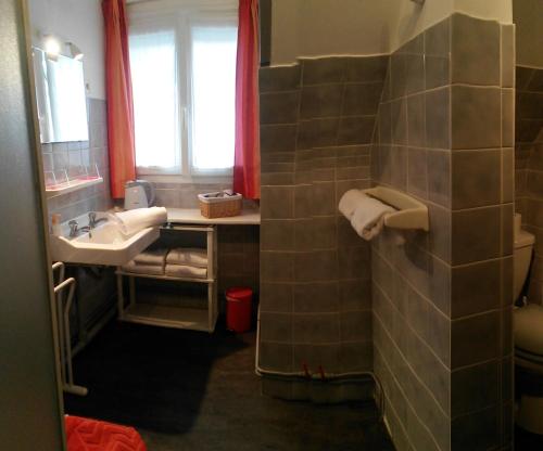 une salle de bain avec un lavabo et un miroir dans l'établissement Arroplace, à Arromanches-les-Bains