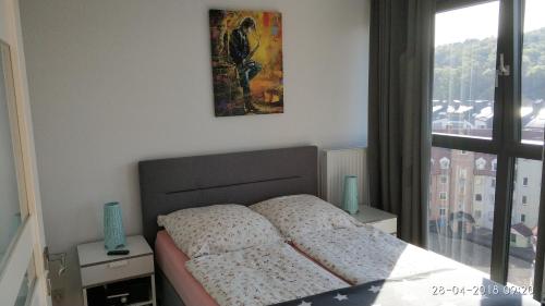 a bedroom with a bed with a picture on the wall at Horyzont 803 in Międzyzdroje