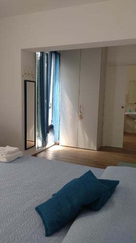 a bedroom with a bed with a blue pillow on it at La vie est belle in Finale Ligure