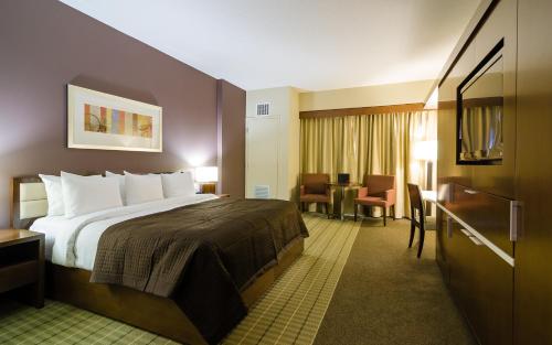 a hotel room with a bed and a table at Hotel Casino New Nouveau Brunswick in Moncton