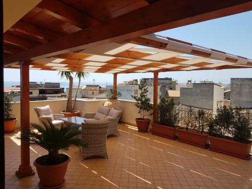 eine Terrasse mit Stühlen und Tischen auf dem Dach in der Unterkunft B&B e Casa Vacanza al Castello in Roccella Ionica