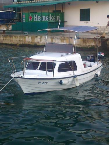 a white boat is docked in the water at Luštica Apartments in Lustica