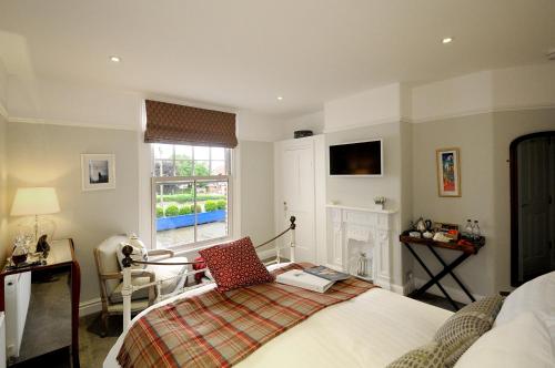 a bedroom with a bed and a desk and a window at Corner House Bed & Breakfast in West Runton