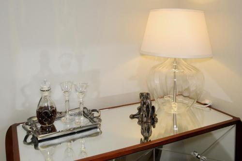 a table with a lamp and wine glasses on it at Corner House Bed & Breakfast in West Runton