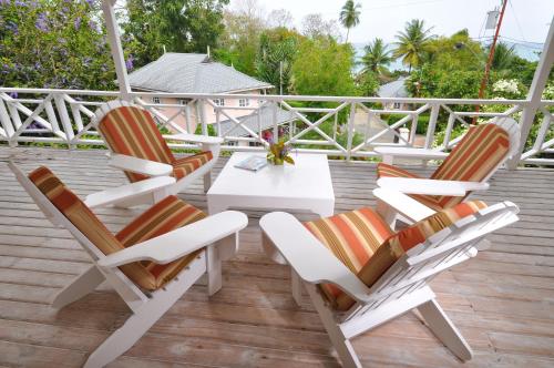 three chairs and a table on a deck at Plantation Beach Villas in Black Rock