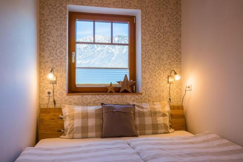 a bedroom with a bed with a window and a snow covered mountain at Apartment Buchsteiner in Haus im Ennstal