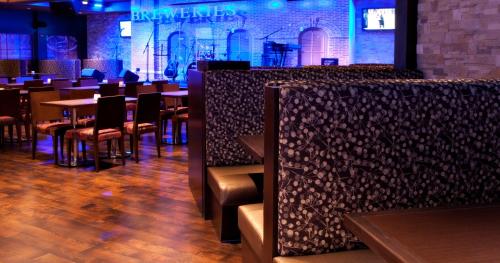 a restaurant with tables and chairs and a bar at Hotel Casino New Nouveau Brunswick in Moncton