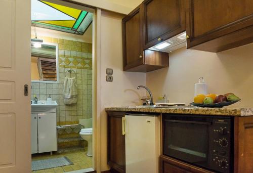 a kitchen with a sink and a bowl of fruit on the counter at Elois Suites in Rethymno Town