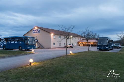 two buses parked in front of a building at Hôtel Azur Saint Junien Cit'Hotel in Saint-Junien