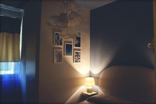 a bedroom with a bed and a light on the wall at Pineta del Borgo in Cavi di Lavagna