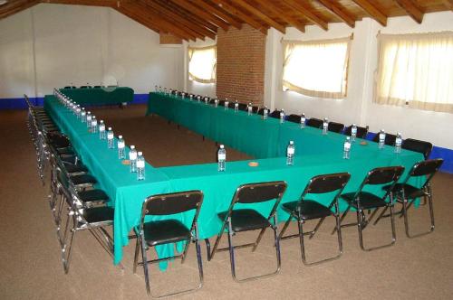 a long green table and chairs in a room at Hotel Bella Vista in Huasca de Ocampo